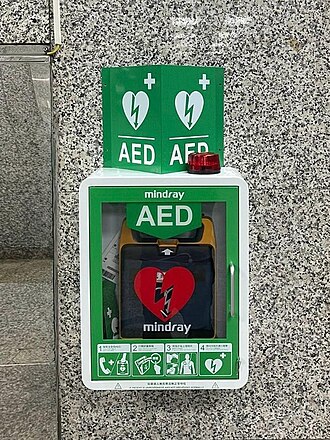 Person using an automated external defibrillator during emergency training